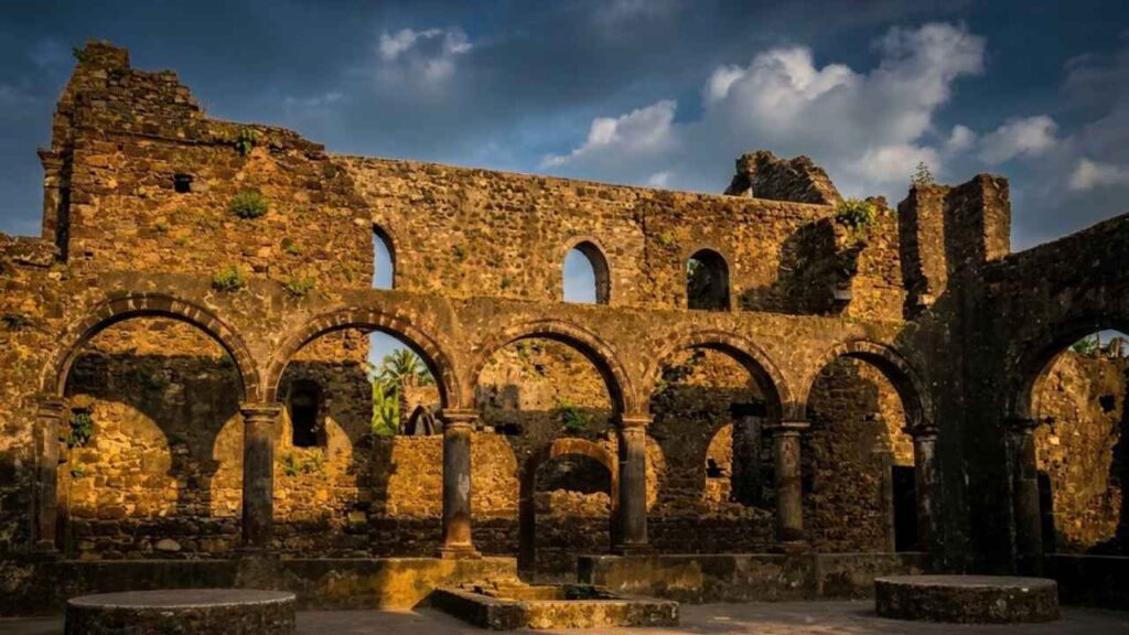 Ruined buildings and palm trees inside Vasai Fort